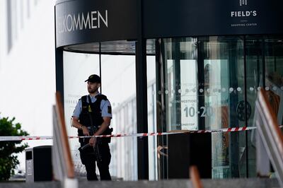 A police officer stands in front of the closed Field's shopping mall in Copenhagen, Denmark, on Monday. AP