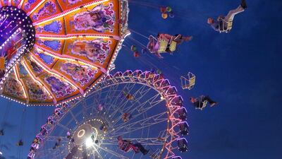 Visitors ride on a swing and on a Ferris wheel at the 581st ‘Cranger Kirmes’ funfair in Herne, Germany. Ina Fassbender / EPA