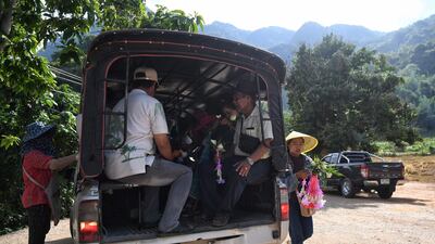 Visitors boarding a shuttle car to take them to the entrance of the Tham Luang cave. AFP