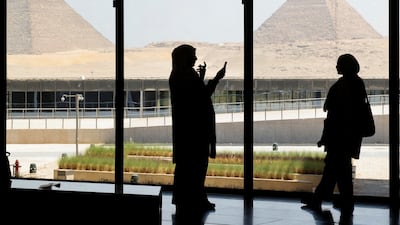 Tourists take pictures with the pyramids in the background as they visit the Grand Egyptian Museum on the outskirts of Cairo. Reuters