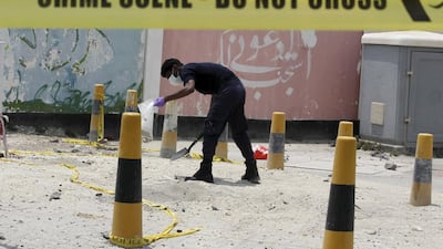 An explosives specialist police officer collects bomb samples after a blast in the village of Sitra, south of Manama, Bahrain, on July 28, 2015. Hamad I Mohammed / Reuters
