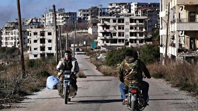 Syrian pro-government forces drive motorbikes in the strategic town of Salma, in the coastal Latakia province, on January 15, 2016, following its recapture from rebel fighters. Youssef Karwashan/AFP