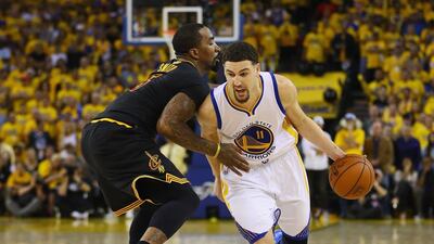 Klay Thompson, No 11, of the Golden State Warriors drives against JR Smith, No 5, of the Cleveland Cavaliers during the second half in Game 7 of the NBA Finals at Oakland, California. Ezra Shaw / Getty Images / AFP