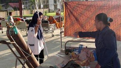 A paramedic tends to an injured child at a makeshift room after an earthquake hit Sinabang today.