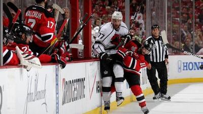 Stephen Gionta of the New Jersey Devils checks Jeff Carter of the Los Angeles Kings