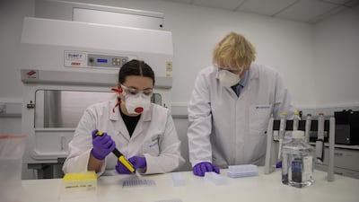 UK Prime Minister Boris Johnson watches a quality control technician at work at Valneva's biotechnology laboratory in Livingston, Scotland. AFP