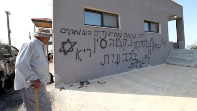 Graffiti on a building in the West Bank village of Deir Abu Mashal where Israeli settlers set fire to a car. EPA