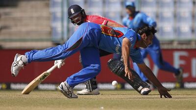 Afghanistan's Shapoor Zadran dives to stop the ball as England's James Vince watches. REUTERS/Adnan Abidi