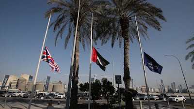 A British national flag, left, and the Emirati flag, centre, fly at half-mast during the mourning period and in honour of Queen Elizabeth II. EPA