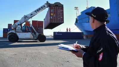 A Tunisian customs officer looks on as containers filled with Italian waste illegaly imported into the country are carried to be loaded onto a ship to be returned to the Italian port of Salerno, in the Mediterranean port city of Sousse, on February 19, after an agreement was signed between the two countries for the containers to be sent back. - Tunisia will return more than 280 containers of waste illegally imported from Italy in 2020, the north African country's environment ministry said this week. The containers were brought in by a Tunisian company that falsely claimed that the household waste -- barred from import under Tunisia law -- was in fact plastic scrap to be recycled. (Photo by ANIS MILI / AFP)