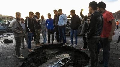 Locals look at the destruction after a massive car bomb exploded at a used-car market in southern Baghdad on February 16, 2017. Ahmad Mousa / AFP