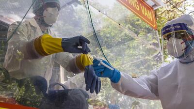 An Indian health official gives a nasal swab to his colleague inside a COVID-19 mobile testing van before collecting samples from people, as India remains under an unprecedented extended lockdown. Getty