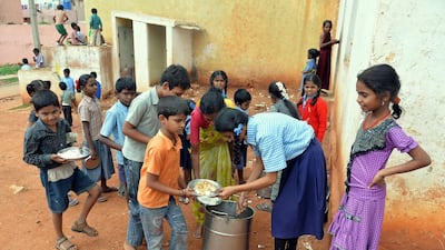 Indian school children attending a government school line-up for the mid-day meal outside their classrooms near lavatories in Bangalore on July 19, 2013. The new government is asking Pepsi to develop nutritious processed foods to be included in school lunches around the country. Manjunath Kiran/AFP Photo