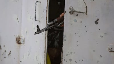 The barrel of an Indian paramilitary soldier's weapon is seen between partially closed doors of an armored vehicle as they drive towards the site of an operation in Awantipora area, south of Srinagar, Indian-controlled Kashmir, on Wednesday, May 6, 2020. AP