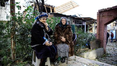 Women, whose houses are damaged, sit near the blast site hit by a rocket during the fighting over the breakaway region of Nagorno-Karabakh in the city of Ganja, Azerbaijan. Reuters