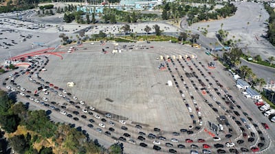 People in cars line up to be tested for Covid-19 in a parking lot at Dodger Stadium, in Los Angeles, California. AFP