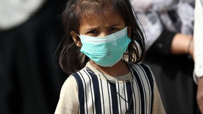 A child wears a protective face mask after cases of novel coronavirus were reported in the country and neighboring Afghanistan and Iran, in Karachi, Pakistan. EPA