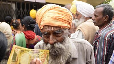 A retired police personnel waits outside to deposit and exchange 500 and 1,000 rupee notes in Amritsar, India. Sameer Sehgal / Hindustan Times via Getty Images