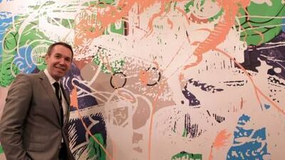 The American artist Jeff Koons poses in front of one of his painting displayed at the Abu Dhabi Art fair at Emirates Palace hotel in Abu Dhabi.