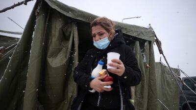 A woman walks out of a tent on the Belarusian side of the EU's eastern border. Reuters