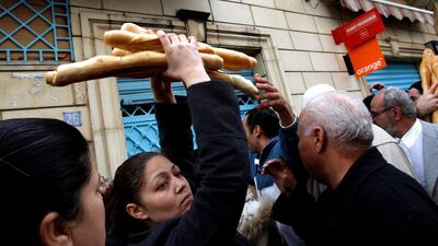 FILE - In this Jan. 17, 2011 file photo, a woman leaves a bakery after buying bread in the center of Tunis. Some call it dangerous, others embrace it as revolutionary: an initiative by Tunisia's president to make inheritance and marriage rules fairer to women has divided his country and reverberated across the Muslim world. (AP Photo/Christophe Ena, File)