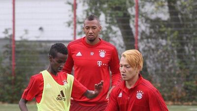 Jerome Boateng of Bayern Munich observes refugee youths playing during a training session put on by the club this week for refugees. Alexandra Beier / Bongarts / Getty Images