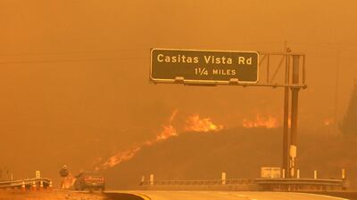 Flames and smoke shroud State Route 33 as a wildfire burns in Ventura, California. Daniel Dreifuss via AP