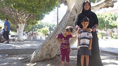 Fatima Syam, at the Unknown Soldier park with her grandchildren, Rahaf, 3, and Ali, in Gaza City July 24,2014 .ÒThey need to get out,Ó said Mrs Syam, 47, referring to the nearby apartment that t other relatives have crammed into over the last week.More than 100,000 Gazans have been displaced by the fighting that erupted on July 8, according to the United Nations. More than 750 Palestinians have been killed and more than 4,000 wounded. (Photo by Heidi Levine for The National).