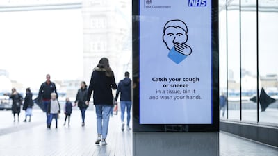 Pedestrians walk past a digital billboard displaying a UK government coronavirus information notice in London, UK. Bloomberg