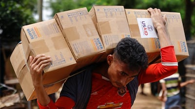 A Rohingya man carries USAID packages as he transports them to a warehouse at a refugee camp in Cox's Bazar, Bangladesh. Reuters