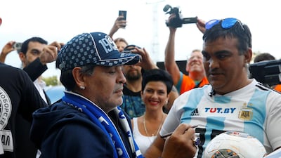 Diego Maradona signs an Argentina shirt for a Dynamo Brest fan. Reuters