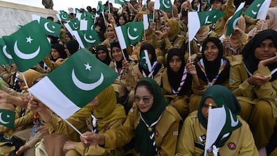 Pakistanis wave their national flag during Independence Day celebrations. EPA