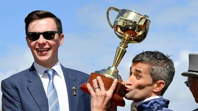 Jockey Corey Brown, right kisses the winning trophy. Andy Brownbill / AP Photo