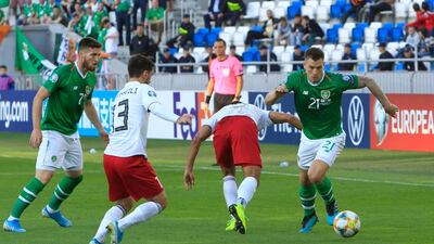 Ireland's James Collins, right, fights for the ball with Tornike Okriashvili of Georgia. AP