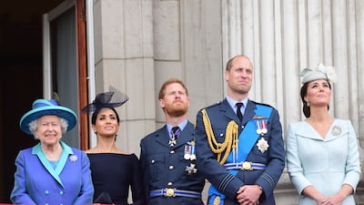Queen Elizabeth, Meghan, Prince Harry, Prince William and Catherine watch the RAF 100th anniversary flypast from the balcony of Buckingham Palace in July 2018. Getty Images