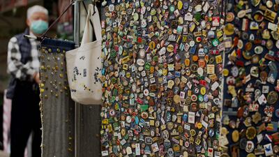 A badge seller stands next to his wares on a street in Taipei, Taiwan. AFP