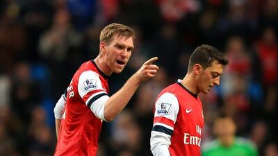 Per Mertesacker, left, of Arsenal has words with teammate Mesut Oezil during their loss at Manchester City on Saturday. Richard Heathcote / Getty Images