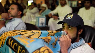 Othman Said Saif of Al Ain reacts to the action on a TV screen as he and about hundred other fans gather to watch the Manchester United v Manchester City game at the Clubhouse at the Zayed Sports City in Abu Dhabi. Silvia Razgova / The National