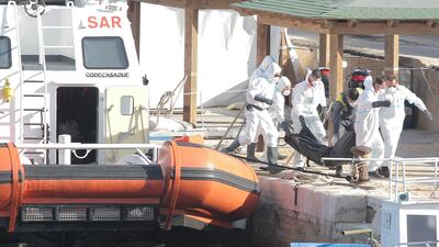 Italian coastguards carry the body of a migrant victim of a boat that capsized off the Italian coast, on the island of Lampedusa, Italy November 30, 2019. REUTERS/Mauro Buccarello
