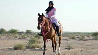 Hanan al Muhairi, 24, of Ras al Khaimah, takes a ride in the desert on a horse from the police stables.