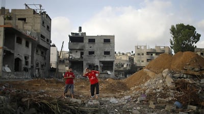 Two Palestinian men stand amidst the rubble of Tayseer Al-Batsh's family house, destroyed in an Israeli air strike in Gaza City (REUTERS/Mohammed Salem)