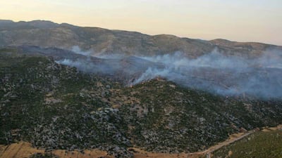 A handout picture released by the official Syrian Arab News Agency (SANA) shows smoke billows from fire in al-Hayluna village, in the western countryside of Syria's Hama governorate. AFP