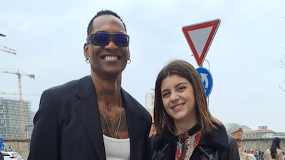 He is wearing a kilt and she is wearing a long gown outside Prada