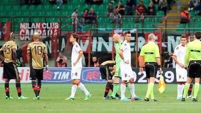 AC Milan players Mario Balotelli, left, and Kevin Prince Boateng with other teammates and Roma players wait for racist chants to stop. Antonio Calanni / AP Photo
