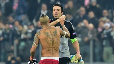 Juventus' Italian goalkeeper Gianluigi Buffon (back) shakes hands with Bayern Munich's Chilean midfielder Arturo Vidal at the end of the UEFA Champions League round of 16 first leg football match between Juventus and Bayern Munich at the Juventus Stadium in Turin on February 23, 2016. AFP PHOTO / GIUSEPPE CACACE