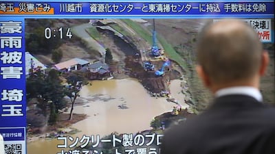 A man looks at TV screen showing a news program with footage of one of areas devastated by Typhoon Hagibis, in Tokyo. Hagibis hit Japan's main island on Saturday, unleashing strong winds and dumping historic rainfall that caused more than 200 rivers in central and northern Japan to overflow, leaving thousands of homes flooded, damaged or without power. AP Photo