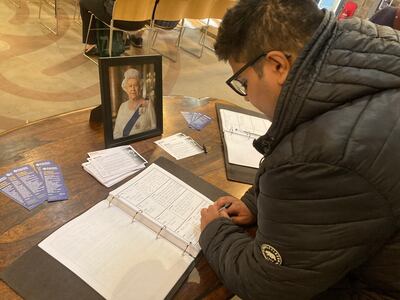 Shabaan Saleem lit a candle and wrote in the book of condolence at Wakefield Cathedral to thank the queen for her support of the Muslim community. Nicky Harley /The National