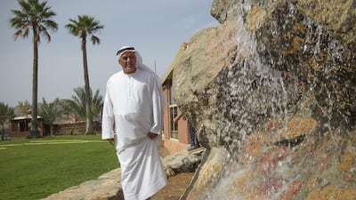 Ali Al Mahrazi proudly stands next to one of the waterfalls he built on his property, which he named the Masafi Water Falls and Cave, left. Mona Al Marzooqi / The National