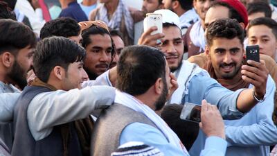 People take a selfie with an alleged Taliban militant as a group of Taliban visit a bazaar to greet people as a goodwill gesture amid a three-day ceasefire on first day of Eid al-Fitr, in Kunduz, Afghanistan, 15 June 2018. Stringer / EPA