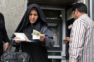 People withdraw money from an automated teller machine in the Iranian capital Tehran's grand bazar. AFP